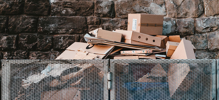 Stack of cardboard boxes in outdoor recycling bin